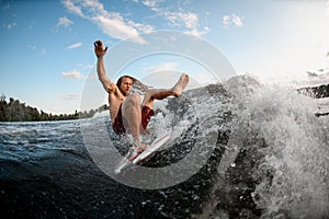 Young wakesurf man falls from board on wave. photo