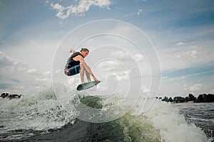 Young wakesurf rider jumping on the waves of the river photo