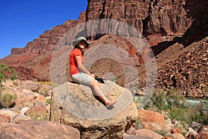 Young waoman backpacker by Hance Rapids in the Grand Canyon.