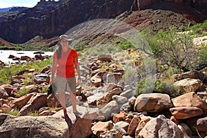 Young waoman backpacker by Hance Rapids in the Grand Canyon.