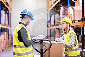 Young warehouse workers working together.