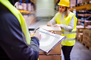 Young warehouse workers working together.