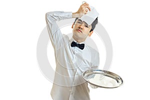 The young weary waiter appended to the head cloth and holding a tray