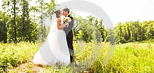 Young wedding couple enjoying romantic moments outside on a summer meadow