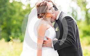 Young wedding couple enjoying romantic moments outside on a summer meadow