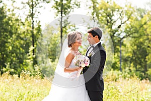 Young wedding couple enjoying romantic moments outside on a summer meadow