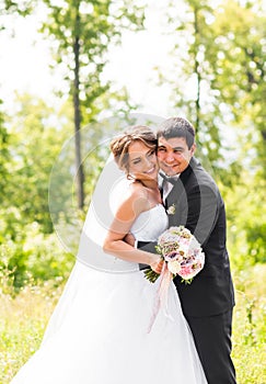 Young wedding couple enjoying romantic moments outside on a summer meadow