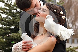 Young wedding couple with pigeons pair, broom kiss bride over pa