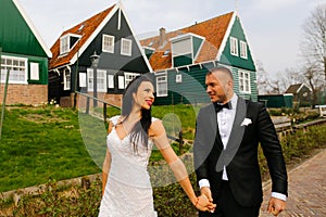 Young wedding couple posing near houses