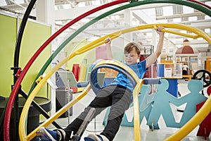 Young white boy in science centre using human gyroscope