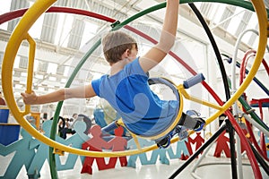 Young white boy using a human gyroscope, back view