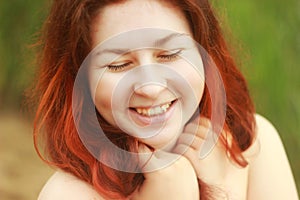 A young white Caucasian woman joyfully smiles and laughs with cute dimples on her cheeks.