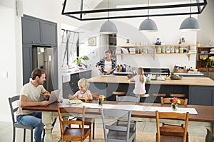 Young white family busy in their kitchen, elevated view