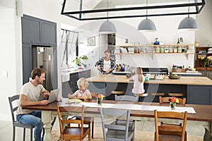 Young white family busy in their kitchen, elevated view photo