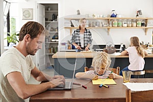 Young white family of four busy in their kitchen, close up photo