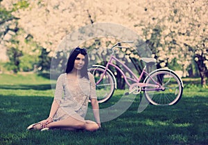 Young white girl with bicycle in spring park