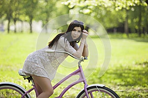 Young white girl with bicycle in spring park