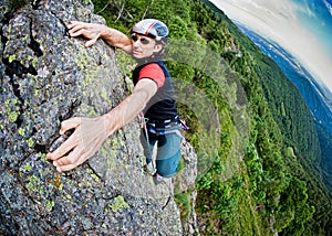 Young white man climbing a steep wall