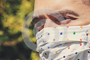Young white man with a fabric handmade face mask during coronavirus pandemic. Coronavirus, COVID-19 outbreak. Virus protection