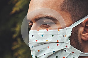 Young white man with a fabric handmade face mask during pandemic; COVID-19 outbreak. protection