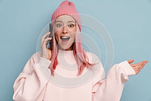 Young white woman exclaiming while talking on mobile phone