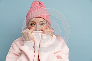Young white woman smiling and hiding her face behind sweatshirt