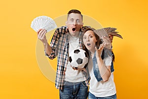 Young win couple, woman man, football fans holding bundle of dollars, cash money, soccer ball, cheer up support team