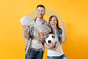 Young win couple, woman man, football fans holding bundle of dollars, cash money, soccer ball, cheer up support team