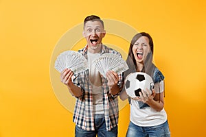 Young win couple, woman man, football fans holding bundle of dollars, cash money, soccer ball, cheer up support team