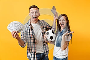 Young win couple, woman man, football fans holding bundle of dollars, cash money, soccer ball, cheer up support team