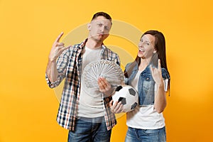 Young win couple, woman man, football fans holding bundle of dollars, cash money, soccer ball, cheer up support team