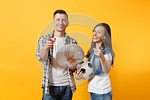 Young win couple, woman man, football fans holding bundle of dollars, cash money, soccer ball, cheer up support team