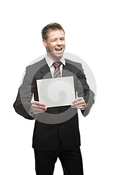 Young winking businessman holding sign