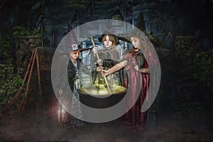 Young witches stirring cauldron photo