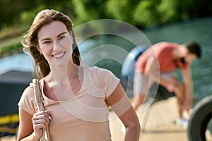 A young womaan standing on the dock while her man untying the boat