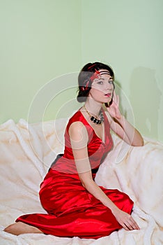 Young woman in 1920 styled costume sitting on fur