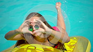 Young woman 20s laying and relaxed near pool at summer holiday. Bikini girl sunbathing lying on inflatable