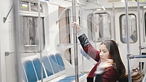 Young woman absorbedly dancing pole dance in moving train