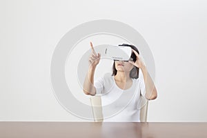 Young woman acting while wearing VR device or virtual reality glasses over white background
