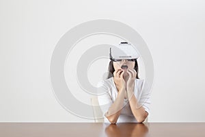 Young woman acting while wearing VR device or virtual reality glasses over white background