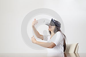 Young woman acting while wearing VR device or virtual reality glasses over white background