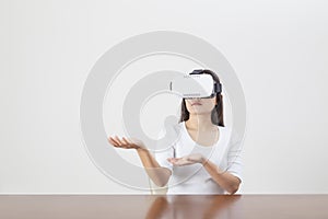 Young woman acting while wearing VR device or virtual reality glasses over white background