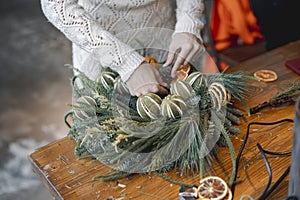 A young woman is actively involved in a workshop crafting Christmas ornaments.