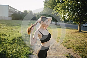 Young woman in activewear exercising outdoors