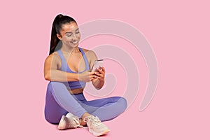 Young woman in activewear using phone post-workout