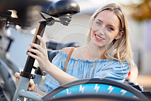 young woman adjusting seat on bicycle