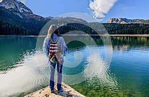 Young woman admires beautiful panorama of Black Lake ( Crno jezero),Durmitor, Montenegro