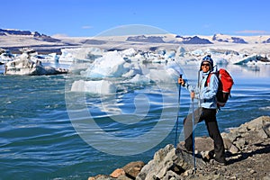 Young woman admires the beauty of the glacial lagoon Jokulsarlon in Iceland