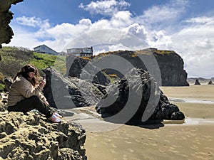 A young woman admiring the beautiful view of Bandon beach in Bandon, Oregon, with the headlands and beautiful coast