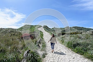 A young woman admiring the Beautiful views of the oregon coast with it`s vast sandy beaches and endless sandy dunes